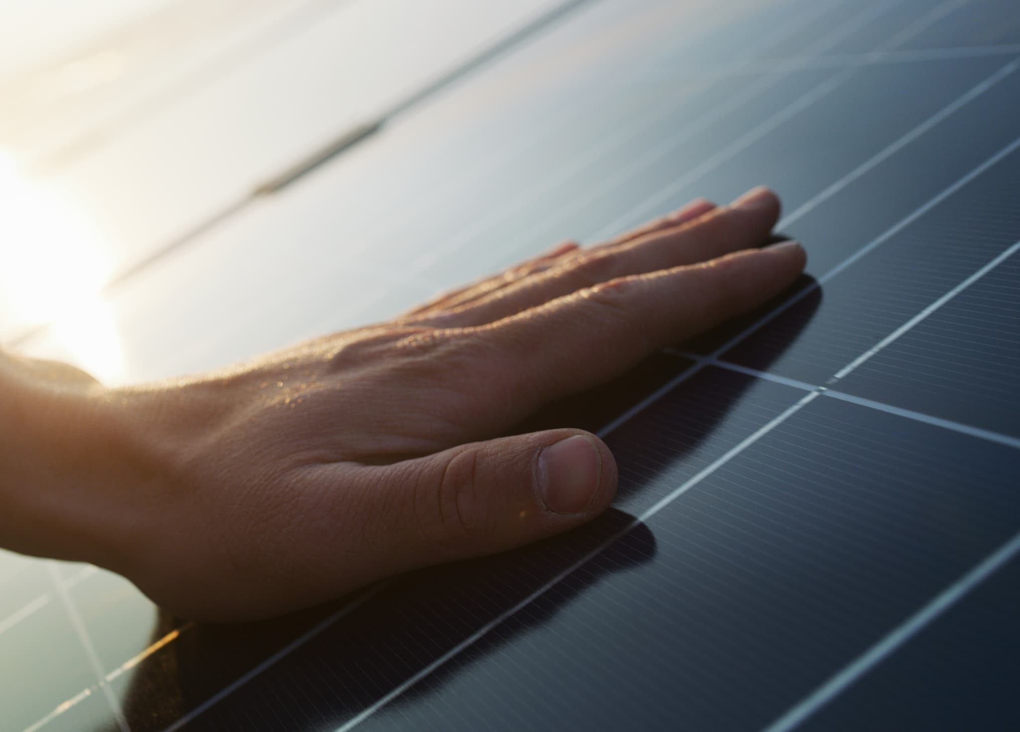 Main en contact avec un panneau solaire